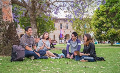 Group of students sit in UQ Great Court.